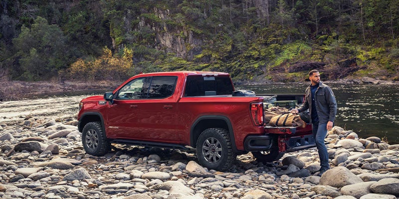 Red 2026 GMC Sierra 1500 parked on rocky off-road terrain