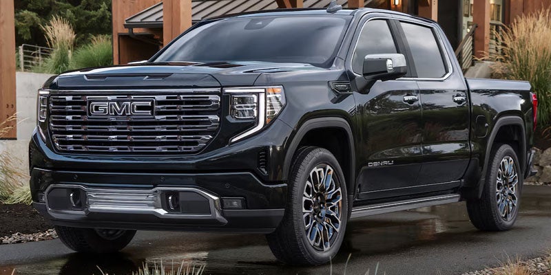 Black 2026 GMC Sierra 1500 parked outside a modern home
